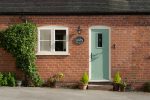 White French casement window left of a green composite door